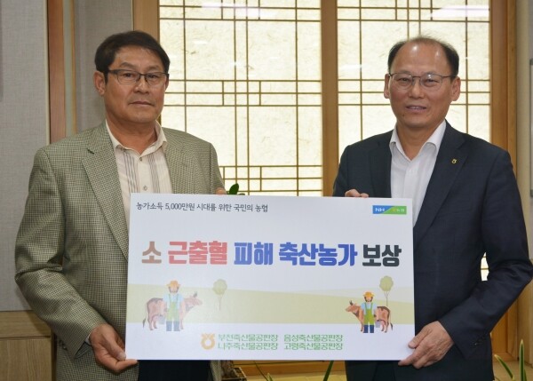 이정재 농장주와 김태환 축산경제대표이사가 기념촬영을 하고 있다