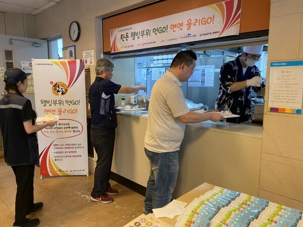 사진은 지난 7월 27일 삼기오토모티브 평택본사 임직원들이 돼지고기 웰빙부위로 만든 수제등심돈까스를 배식받고 있는 모습