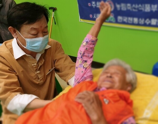 사진은 농촌재능나눔 일반캠프 참석자가 근신경조정술을 통해 통증조절 치료 봉사활동을 하고 있다