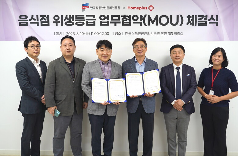 HACCP인증원-홈플러스 음식점 위생등급 업무협약(MOU) 단체사진 / (오른쪽에서 세 번째 홍진환 인증사업이사, 두 번째 김동주 연구개발본부장, 첫 번째 박정현 위생평가팀장, 왼쪽에서 세 번째 송명헌 부문장)