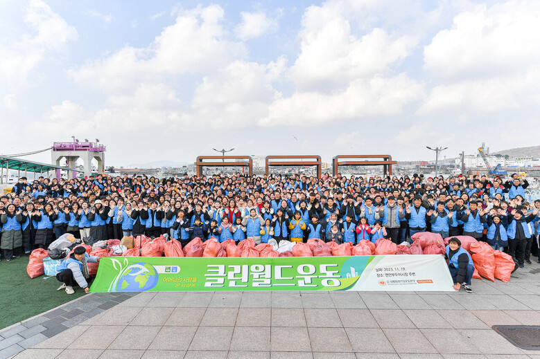 위러브유 인천권 회원 500여 명이 연안부두와 어시장 일대에서 클린월드운동을 펼쳤다. 참가자들이 정화활동 후 상트페테르부르크 광장에서 환하게 웃고 있다.
