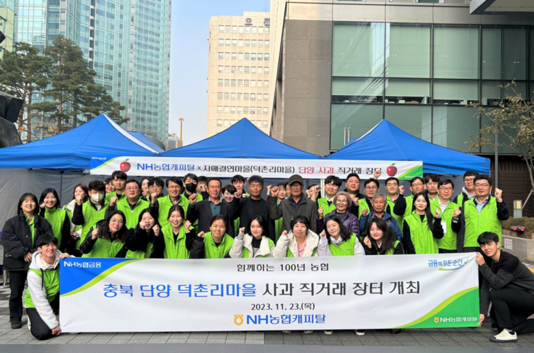 NH농협캐피탈은 23일, 여의도 본사에서 자매결연마을 농산물 직거래장터를 개최했다. 은길수 NH농협캐피탈 부사장(두번째 줄 오른쪽에서 두 번째), 이범구 부사장(두번째 줄 왼쪽에서 다섯 번째), 김종철 상무(두번째 줄 오른쪽에서 첫 번째)와 자매결연 마을 어르신 및 임직원 40여명이 기념촬영을 하고 있다.(농협금융지주 제공)