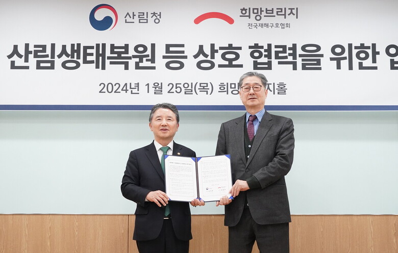 남성현 산림청장(왼쪽)과 송필호 희망브리지 전국재해구호협회 회장이 25일 서울 마포구 희망브리지에서 '산불피해지 산림생태복원 등 상호협력을 위한 업무협약'을 체결한 뒤 기념촬영을 하고 있다.(산림청 제공)