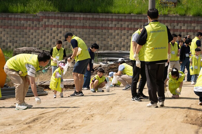 NH농협금융 가족봉사단은 14일, 경기 고양시에서 환경정화 플로깅과 농촌체험을 실시했다. 임직원 가족봉사단이 플로깅을 하고 있다.(NH농협금융 제공)