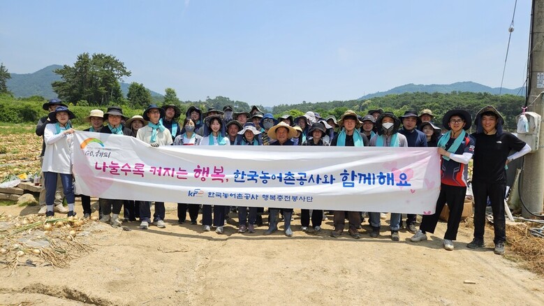 한국농어촌공사 KRC행복충전단이 양파수확 봉사활동을 실시하고 기념사진을 촬영하고 있다.