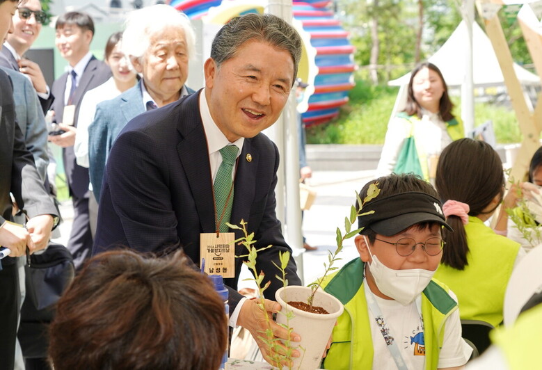 남성현 산림청장이 17일 서울 청계광장에서 열린 세계 사막화와 가뭄방지의 날 기념행사에 참석해 반려식물 만들기 체험행사를 하고 있는 숲사랑청소년단원들을 독려하고 있다.(산림청 제공)
