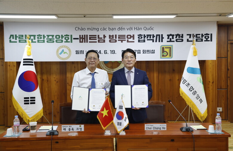 최창호 산림조합중앙회장(오른쪽)과 레 응옥 끄엉(Lê Ngọc Cường) 빙투언임업사 회장이 합의서를 작성하고 기념촬영을 하고 있다.(산림조합중앙회 제공)