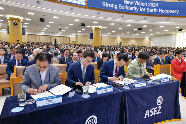 각계 인사들이 전 세계 '지구환경 복원 프로젝트' 이행을 위한 ASEZ 지지서명서에 서명하고 있다. 오른쪽부터 송칸 루앙무닌턴 주한 라오스 대사. 하나님의 교회 총회장 김주철 목사, 조명래 전 환경부 장관, 대한민국 시군자치구의회 의장협의회 최봉환 회장.