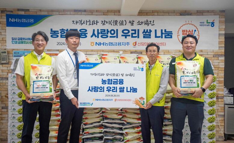 NH농협금융은 28일, 서울 중구 소재 신당데이케어센터에서 우리쌀 나눔 행사를 실시했다. 김익수 농협금융지주 전략기획부문 부사장(왼쪽에서 세 번째), 김무현 신당데이케어센터장(왼쪽에서 두 번째), 박성헌 농협금융지주 경영지원부장(왼쪽에서 첫 번째) 및 직원이 기념촬영을 하고 있다.(NH농협금융 제공)