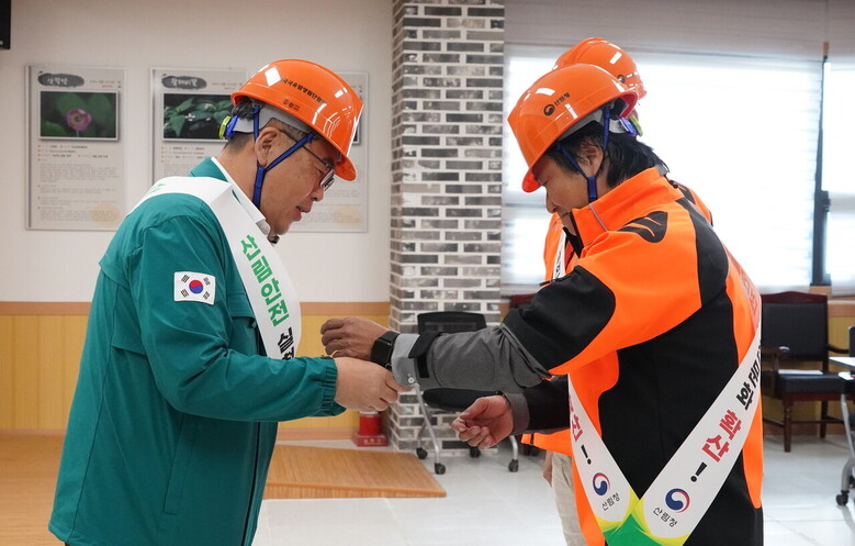 임상섭 산림청장(왼쪽)이 30일 강원도 홍천군에서 개최한 ‘산림안전 결의대회’에서 결의 선서를 마친 뒤 영림단원 손목에 스마트밴드를 채워주고 있다.(산림청 제공)