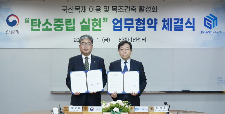  임상섭 산림청장(왼쪽)과 김세용 경기주택도시공사 사장(오른쪽)이 서울 여의도 산림스마트워크 회의실에서 탄소중립을 실현하기 위한 국산 목재 이용 및 목조건축 활성화 업무협약(MOU)을 체결하고 있다(산림청 제공)