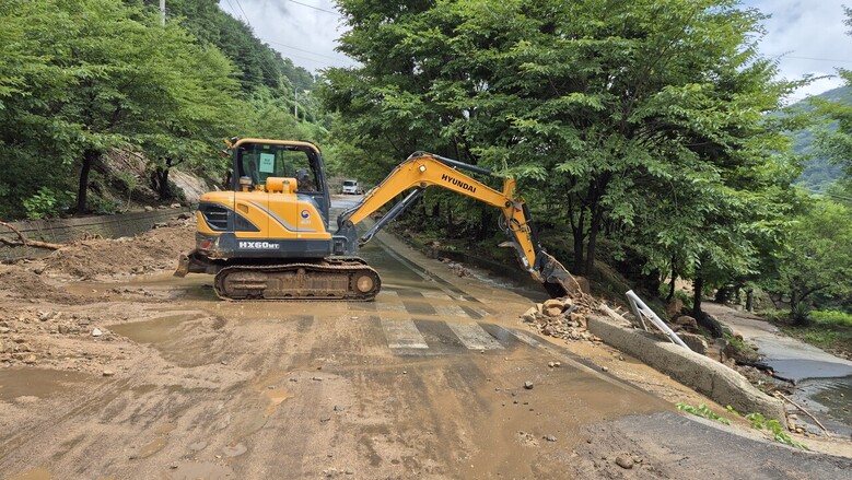 산림청이 투입한 굴착기가 산청군 신안면 안봉리 펜션에 고립된 6명을 구조하기 위해 진입도로를 복구하고 있다.